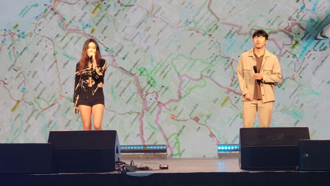 两个人站在舞台上，拿着麦克风唱着歌.